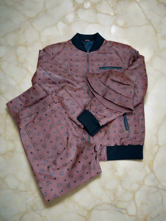 brown mcm customize leather jacket with black print with a leather pants and and a beanie cap place on an ivory marble floor